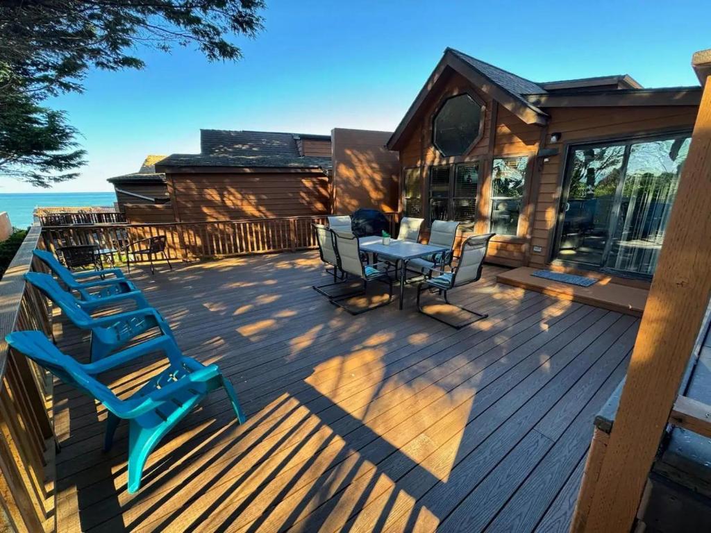 a deck with chairs and a table on a house at Oceanview Cabin 19,jacuzzi, Large Deck W Seating in Smith River