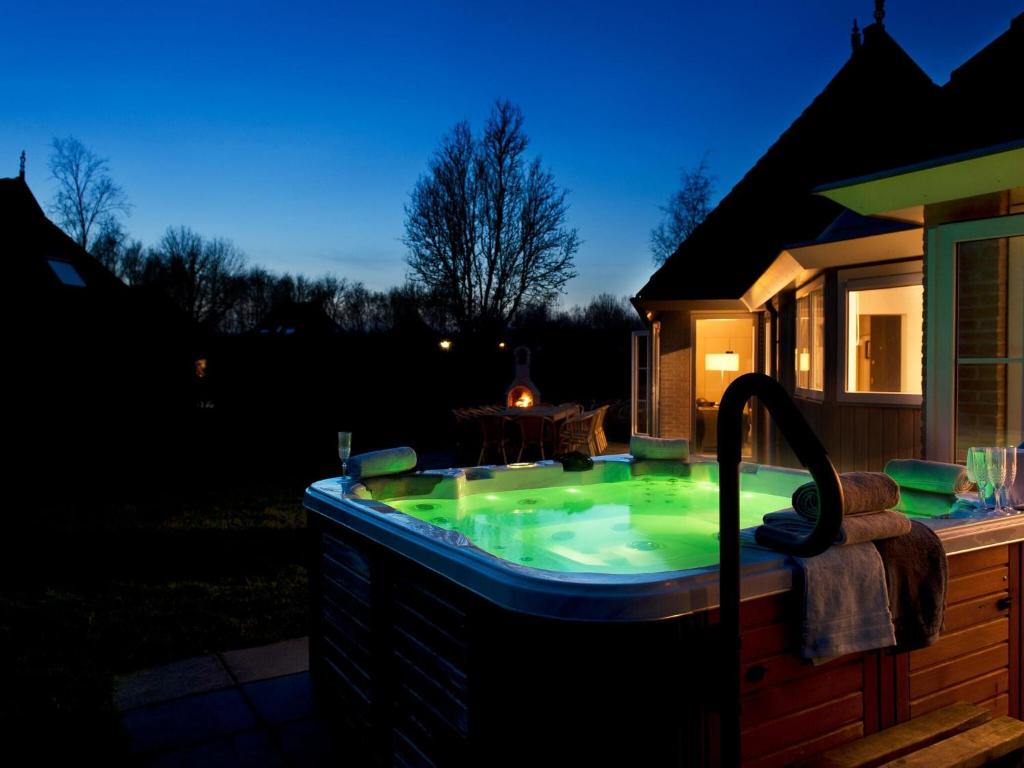 een hot tub in een achtertuin 's nachts bij Family house with sauna, outdoor spa and sloop in Earnewâld
