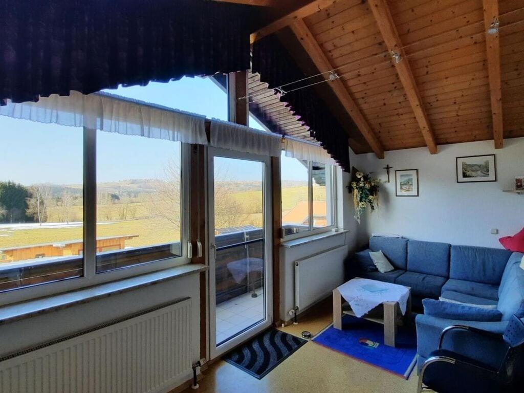 een woonkamer met een blauwe bank en grote ramen bij Nice apartment in Piedmont 
