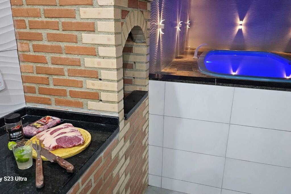 uma cozinha com um balcão com um lavatório azul em Imóvel com piscina e execelente estrutura ! em Araruama