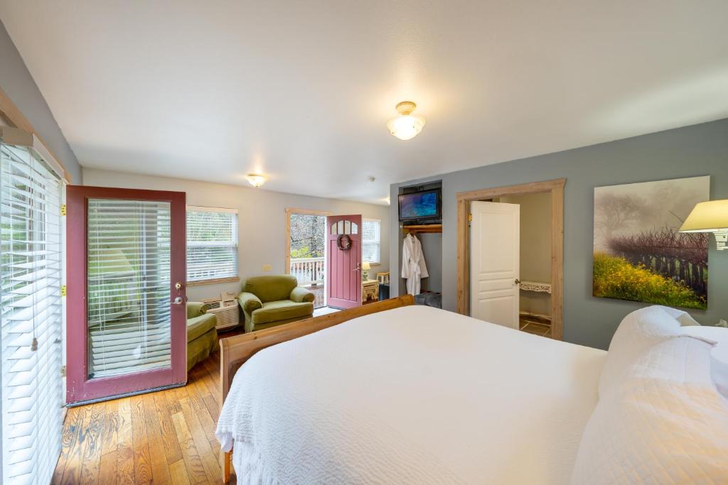 a bedroom with a white bed and a living room at Aurora Park Cottages in Calistoga