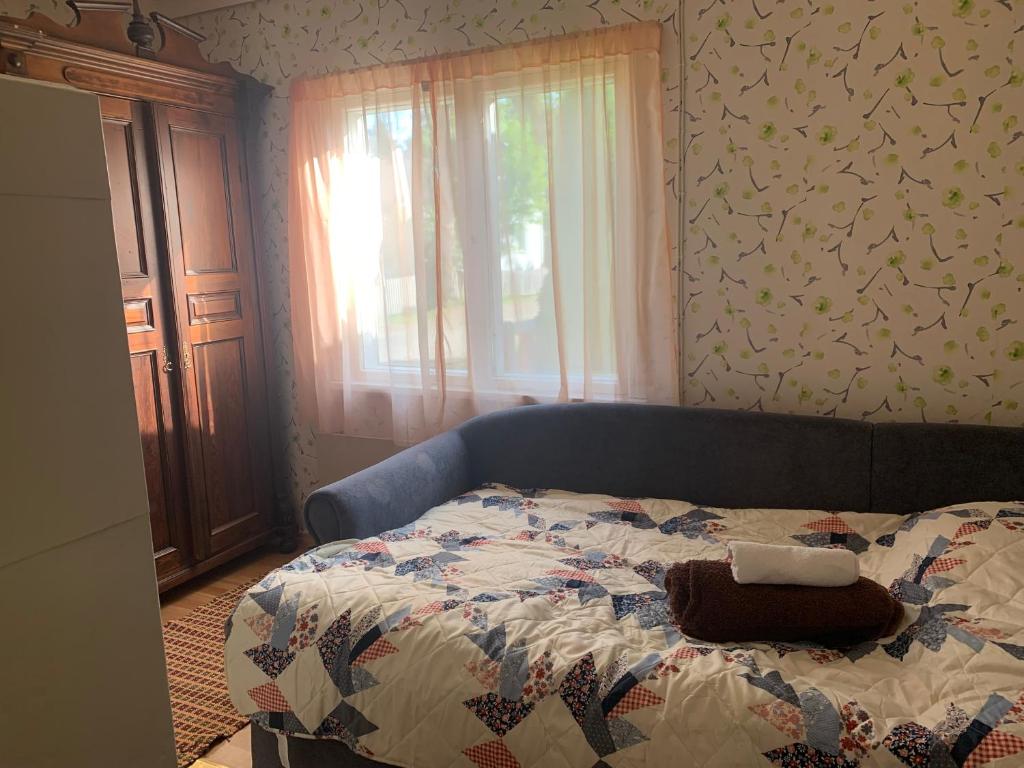 a bed with a quilt on it in a bedroom at Grandma’s house in Iisalmi