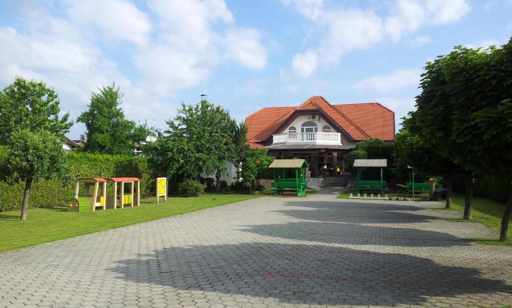 una casa con parque infantil frente a un edificio en Vila Šiftar en Moravske-Toplice