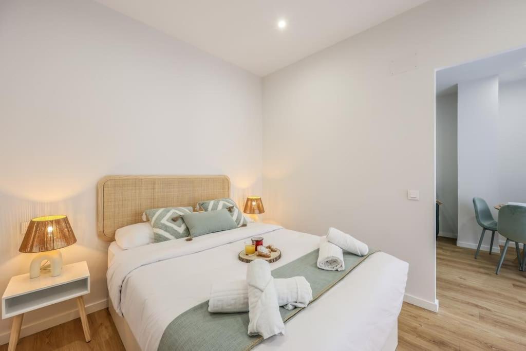 a bedroom with a large white bed with towels on it at Luxe apartments Madrid Rio by RentitUP in Madrid