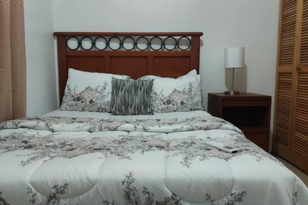 a bedroom with a large bed with a wooden headboard at 10 Min Walk to Ocean Park Beach! in San Juan