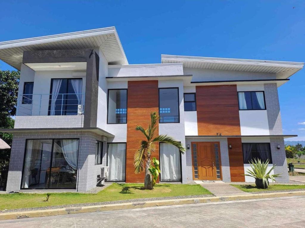 a house with a palm tree in front of it at Mango Prima in Moalboal