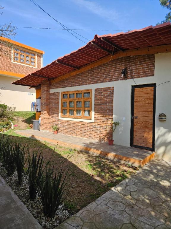una piccola casa in mattoni con una porta marrone di Cabañas en Zacatlán a Zacatlán