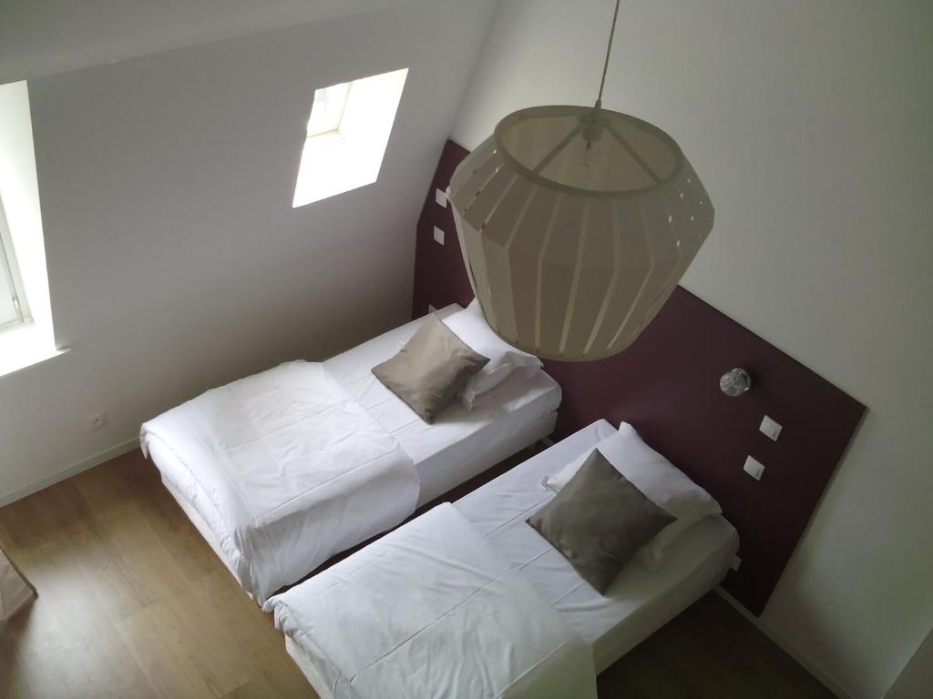 - une petite chambre avec 2 lits et un lustre dans l'établissement Nationale Appart Hotel, à Lille