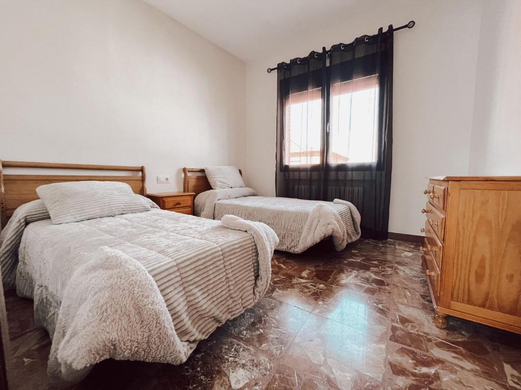 um quarto com 2 camas e uma janela em Casa rural el Retiro de Sancho em Cózar