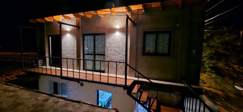 una casa con un reflejo en una piscina de agua por la noche en La Emilia en Cafayate