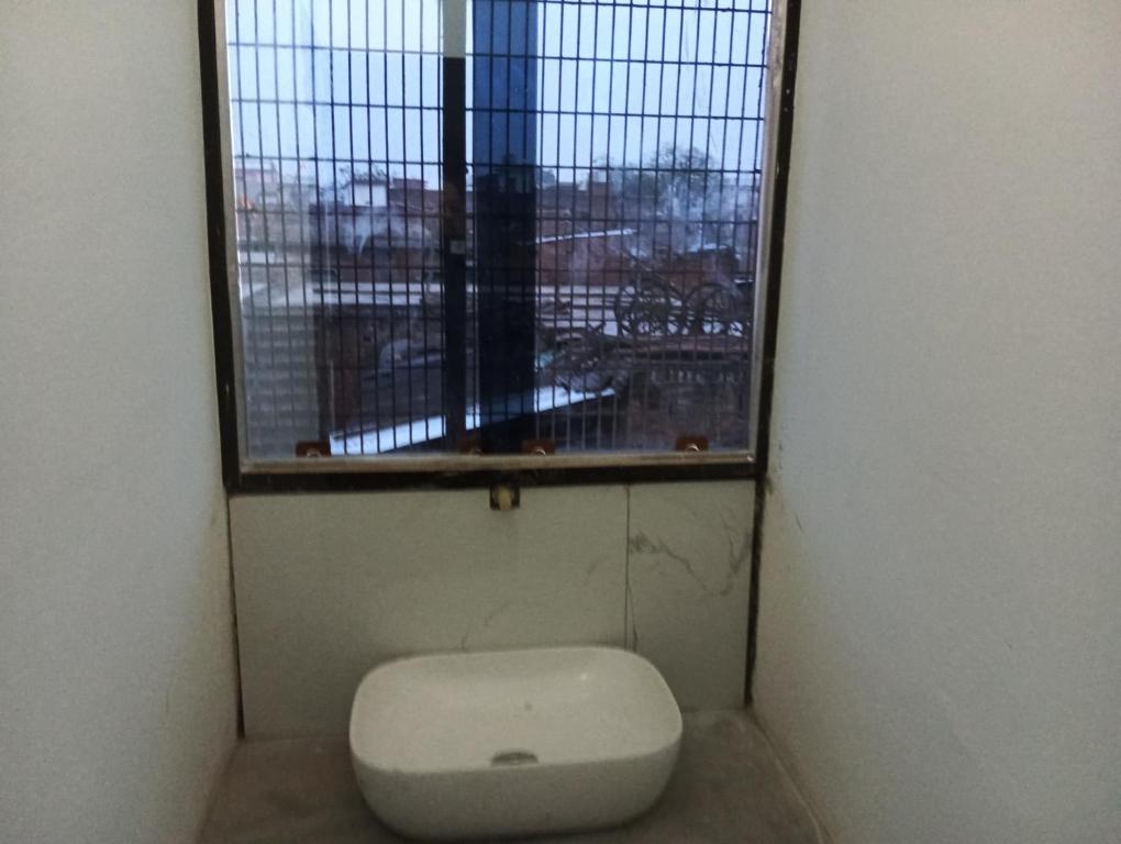 een toilet in een kamer met een raam bij Mahendra home stay in Faizābād