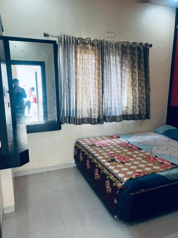 a bedroom with a bed and a window at Hotel sai vasant vihar in Shirdi