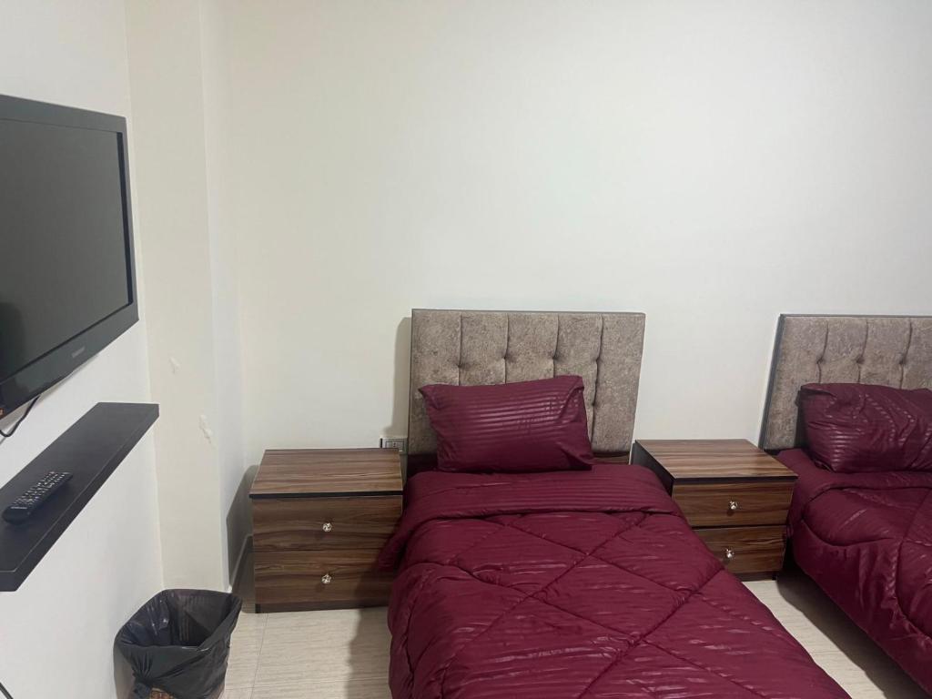 Elegant apartments for rent. في عمّان: غرفة نوم بسرير وتلفزيون بشاشة مسطحة