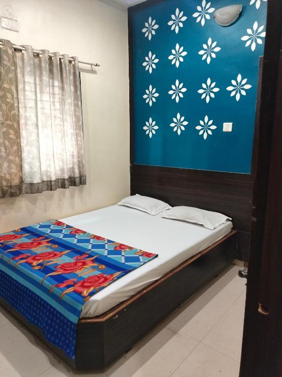 a bed in a room with a blue wall at Hotel sai vasant vihar in Shirdi