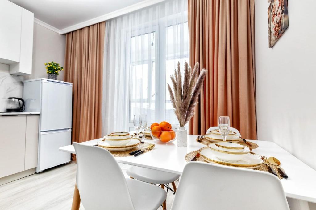 cocina y comedor con mesa blanca y sillas en 1-комнатная Квартира в Астане, en Astana