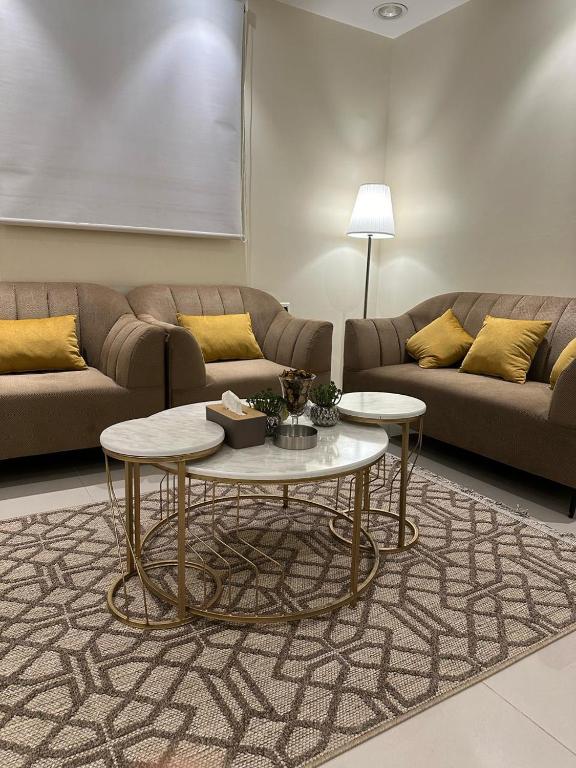 ein Wohnzimmer mit einem Sofa und 2 Tischen in der Unterkunft شقة مفروشة بدخول ذاتي in Al Kharj