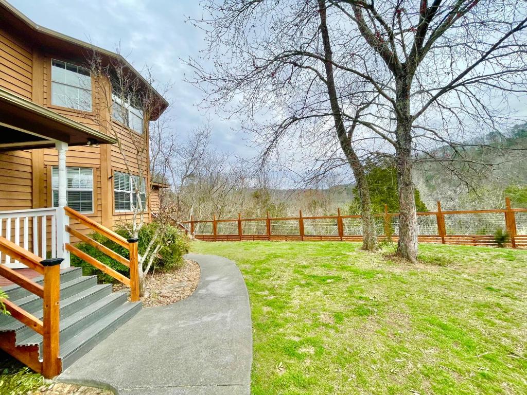 a wooden house with a porch and a tree at 5Bedrooms*4KING BEDS*OUTSTANDING LOCATION*HotTub* in Sevierville
