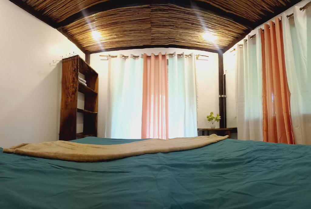 een slaapkamer met een groot bed met blauwe lakens bij Paradise Surf in Dapa