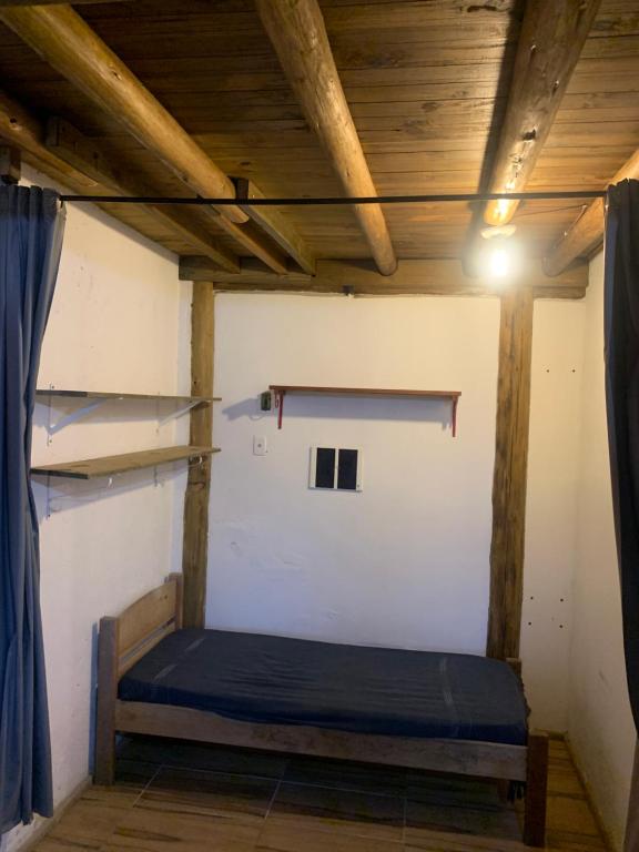 1 dormitorio con 1 cama en una habitación con techos de madera en Casa de aluguel praia do rosa en Garopaba