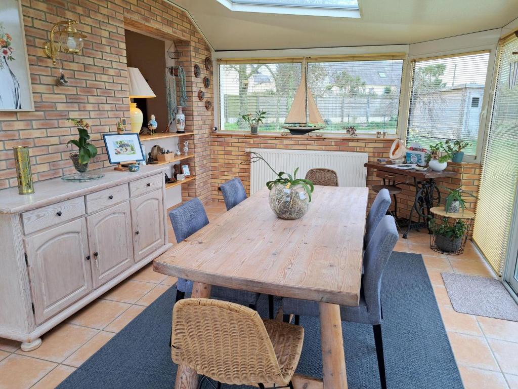 une salle à manger avec une table et des chaises en bois dans l'établissement Holiday Home in St Marguerite near Sandy Beach, à Landéda