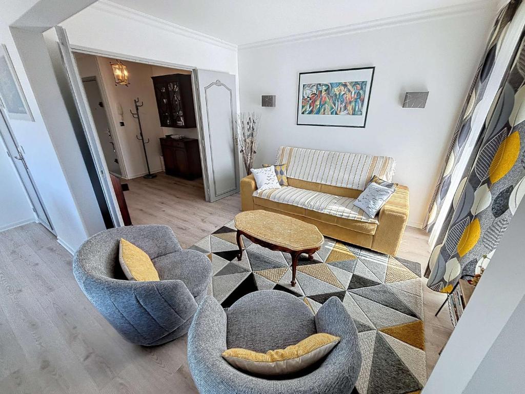 un salon avec deux chaises et un canapé dans l'établissement Appartement au centre de Granville avec garage privatif et Wi-Fi gratuite - FR-1-361-510, à Granville