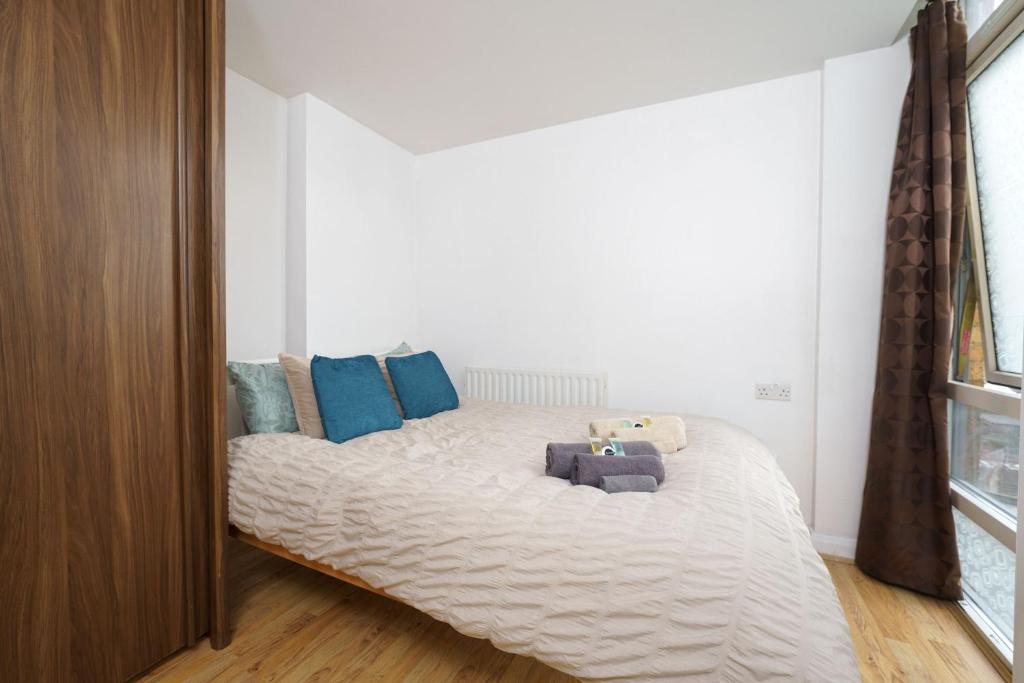 ロンドンにあるBeautiful 1 Bed Apartment with Living Roomのベッドルーム(青い枕の大型ベッド1台付)