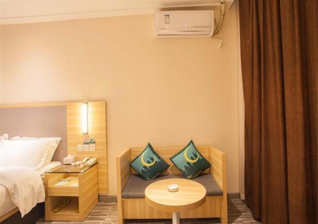 Habitación de hotel con cama y mesa con almohadas en City Comfort Inn Nanning Chaoyang Parkson Pedestrian Street, en Nanning