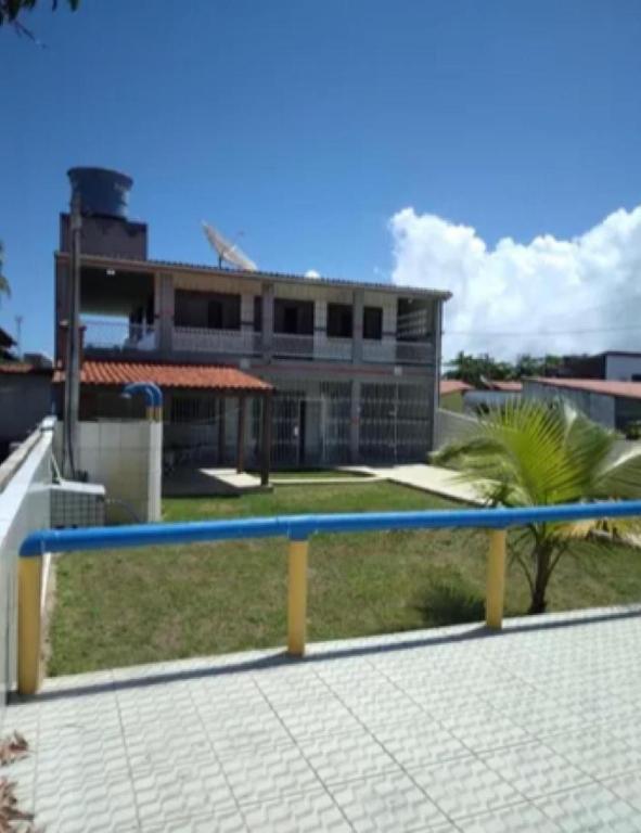 Carneiros Camping Hostel في تامانداري: مقعد أزرق وأصفر أمام مبنى