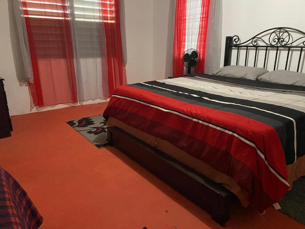 a bedroom with a large bed with red curtains at Apartamentovistadelrio2 in Orocovis