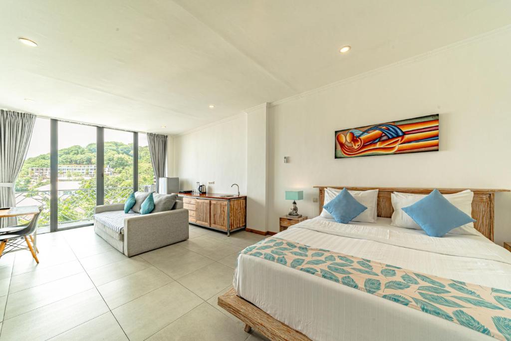 a bedroom with a king sized bed and a chair at Komodo Suites Downtown Managed by CPM Bali in Labuan Bajo