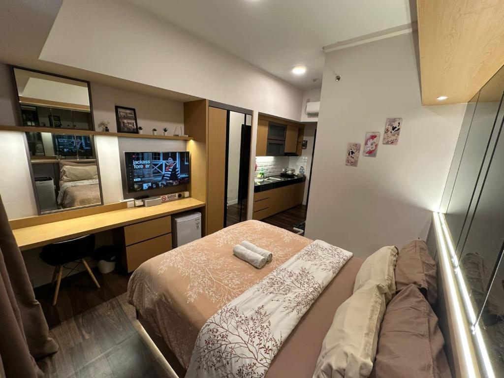 Schlafzimmer mit einem Bett, einem Schreibtisch und einem TV in der Unterkunft LUXURY CASA DE PARCO Apartment Near AEON MALL, THE BREEZE, ICE BSD in Tangerang