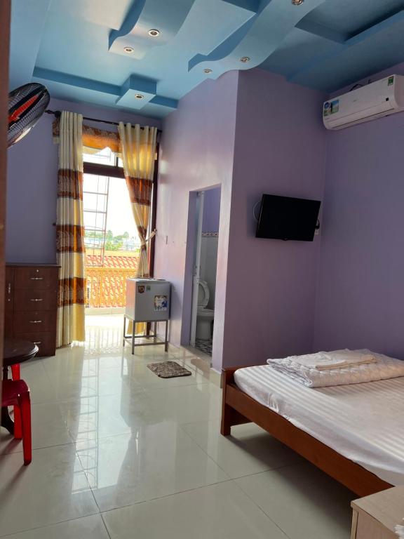 a bedroom with a bed with a blue ceiling at Khách Sạn Như Ý in Ấp Tân Phú (1)