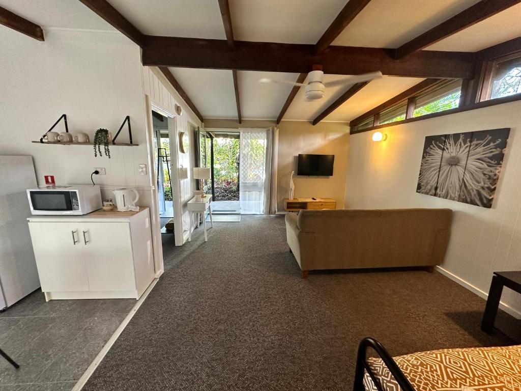 a living room with a couch and a microwave at Colonial Village Resort in Hervey Bay