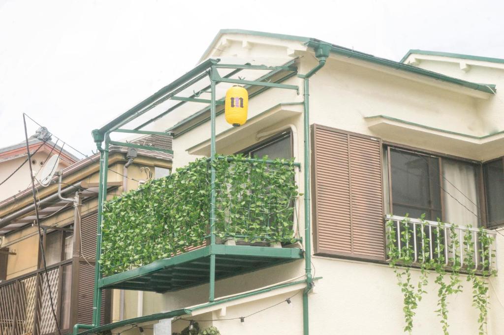 Casa con balcón con luz amarilla. en 滝野苑, en Tokio