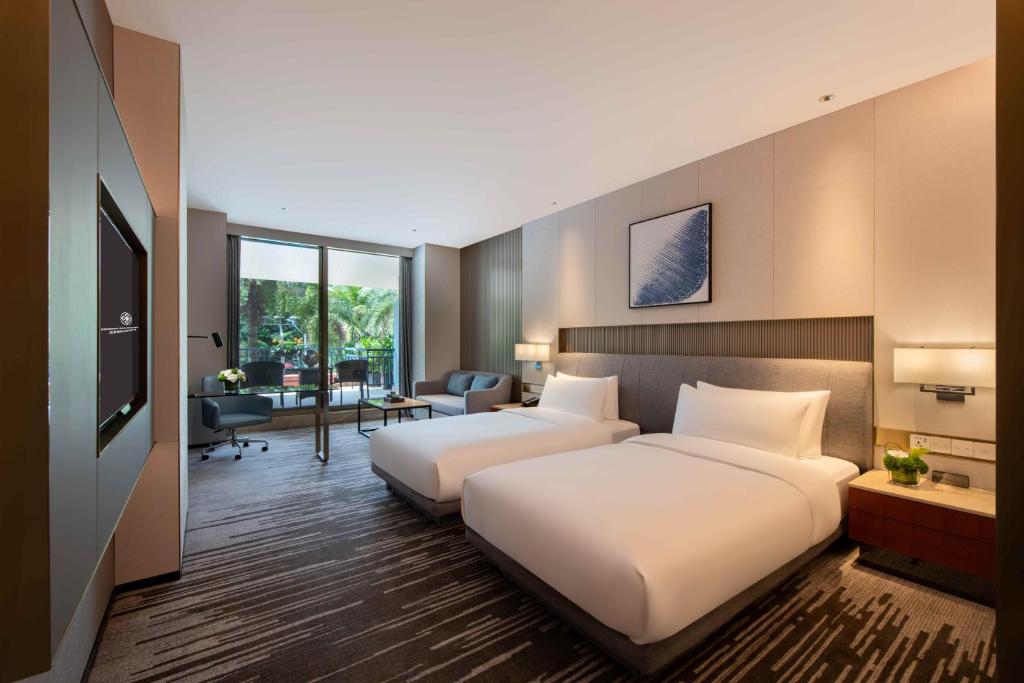 a hotel room with two beds and a living room at Dongguan Forum Hotel and Apartment - Former Pullman hotel Dongguan Forum in Dongguan
