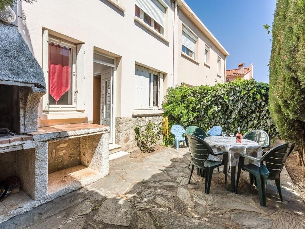 un patio avec une table et des chaises à côté d'un bâtiment dans l'établissement Studio 3 pers avec terrasse près de la plage et des commerces - FR-1-776-80, à Saint-Cyprien