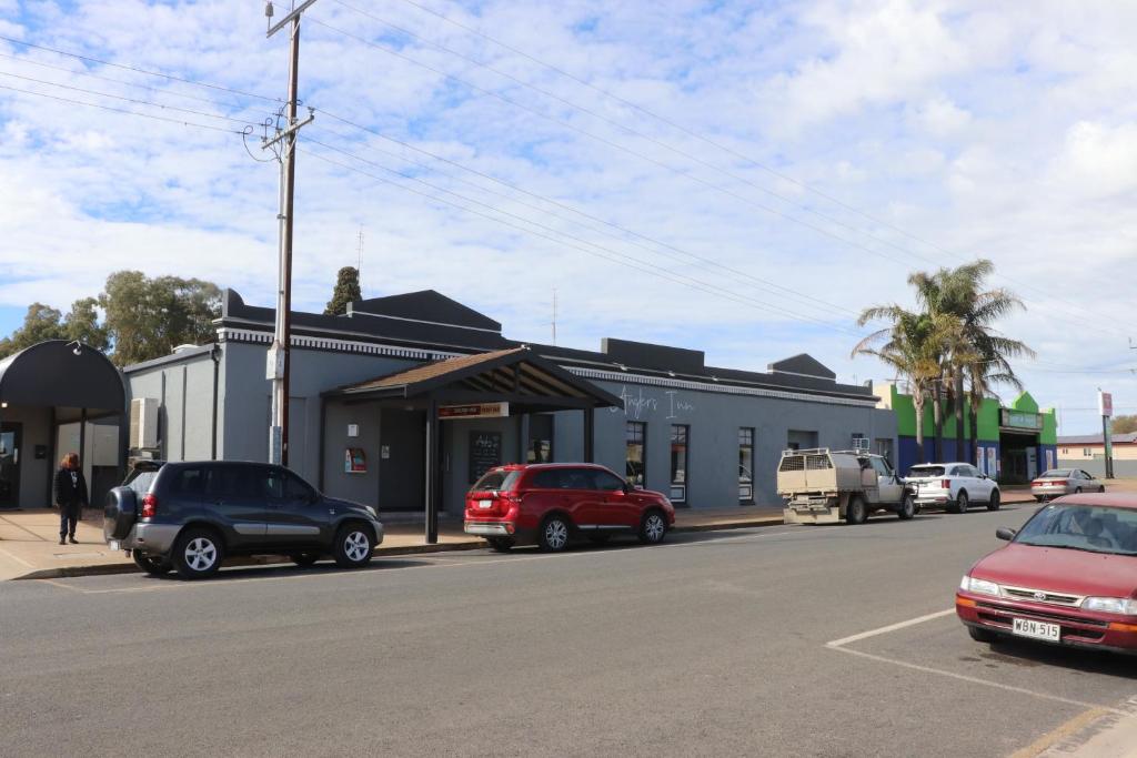 a street with cars parked in front of a building at The Anglers Inn in Wallaroo