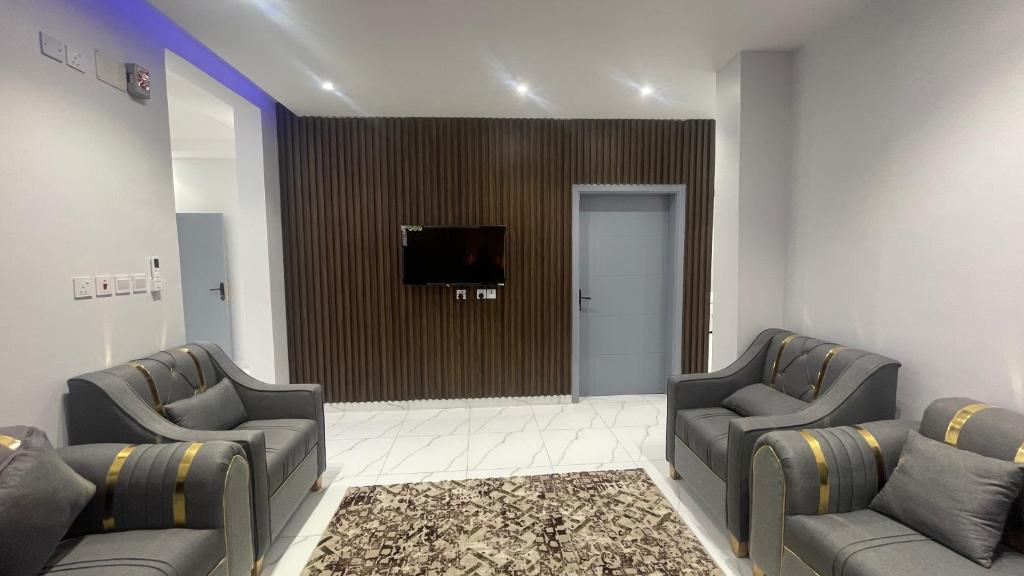 una sala de espera con 2 sillas y TV de pantalla plana en شقة غرفتين وصاله en Al ‘Uqūl