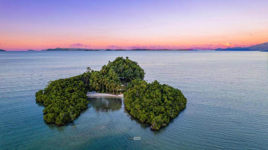 an island in the middle of the ocean at sunset at Boyers island camp site in San Vicente
