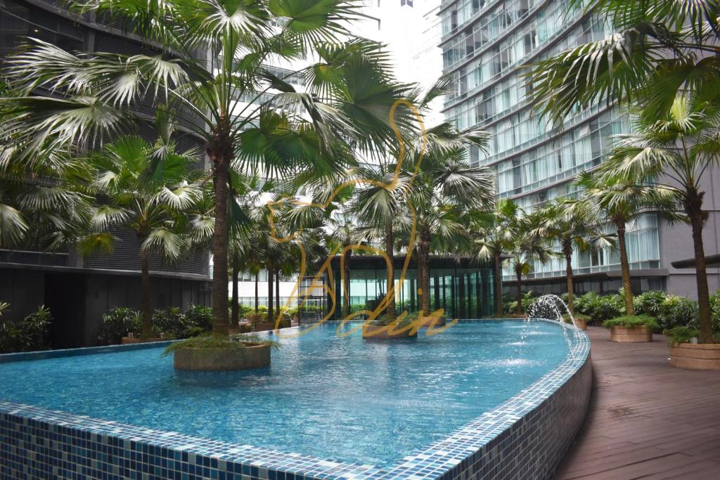 uma grande piscina com palmeiras num edifício em KLCC Skysuites with Private Balcony and Terrace em Kuala Lumpur
