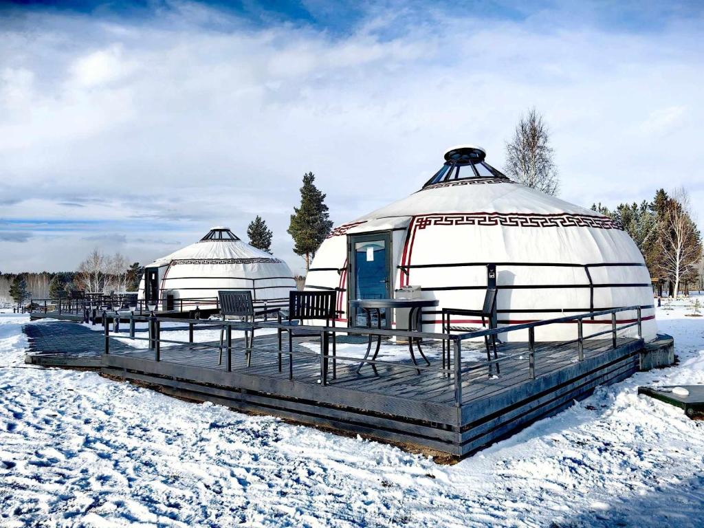 two domes with chairs on a deck in the snow at Tsomtsog Ger, Seven Nuga Resort 