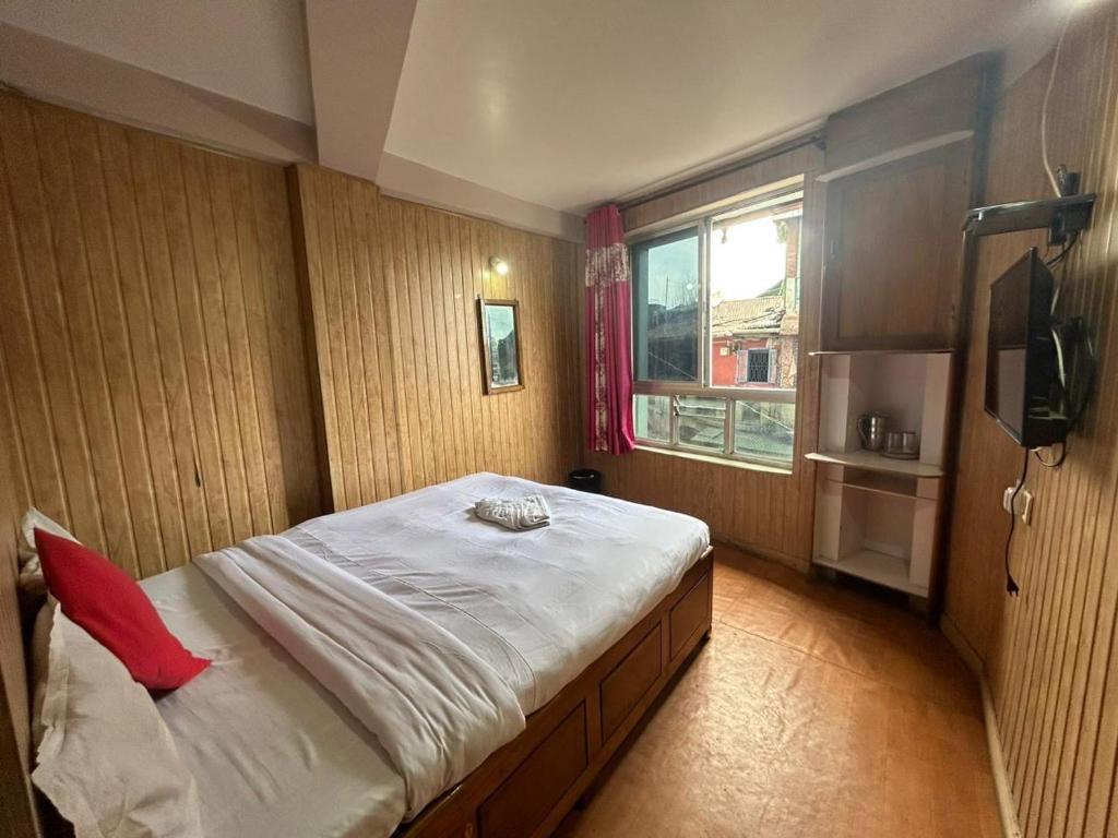 a bedroom with a large bed and a window at Salix in Darjeeling