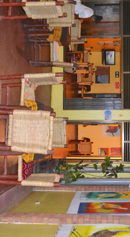 a painting of a room with tables and chairs at Hotel Acacia City in Kampala