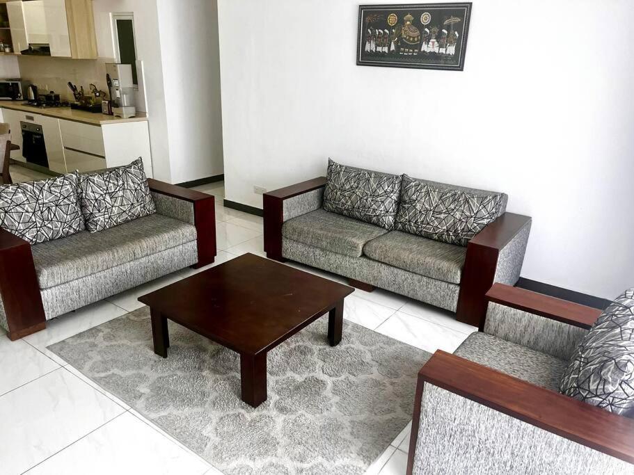 Sala de estar con 2 sofás y mesa de centro en On Golden Mile by Swarg, en Karagampitiya