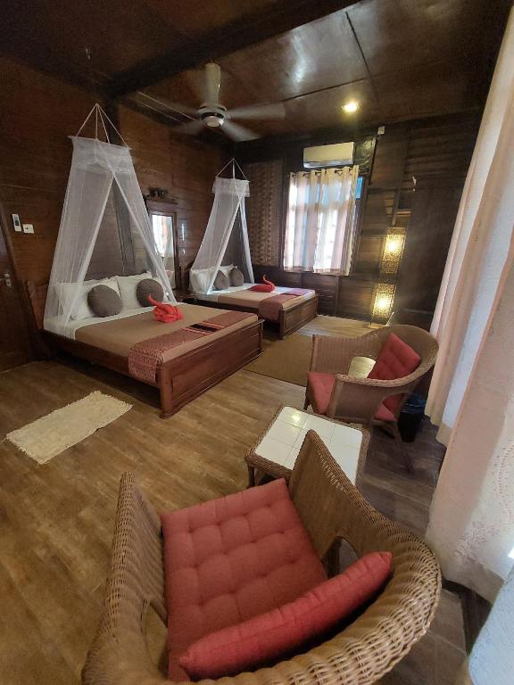 a room with two beds and a couch and chairs at Ombak Dive Resort Perhentian Island in Perhentian Islands