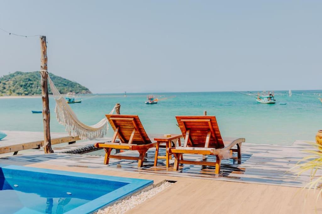 un grupo de sillas y una hamaca en una playa en SeaSalt BeachFront Holiday Home, Private pool, 2 Bedroom house, en Chaloklum