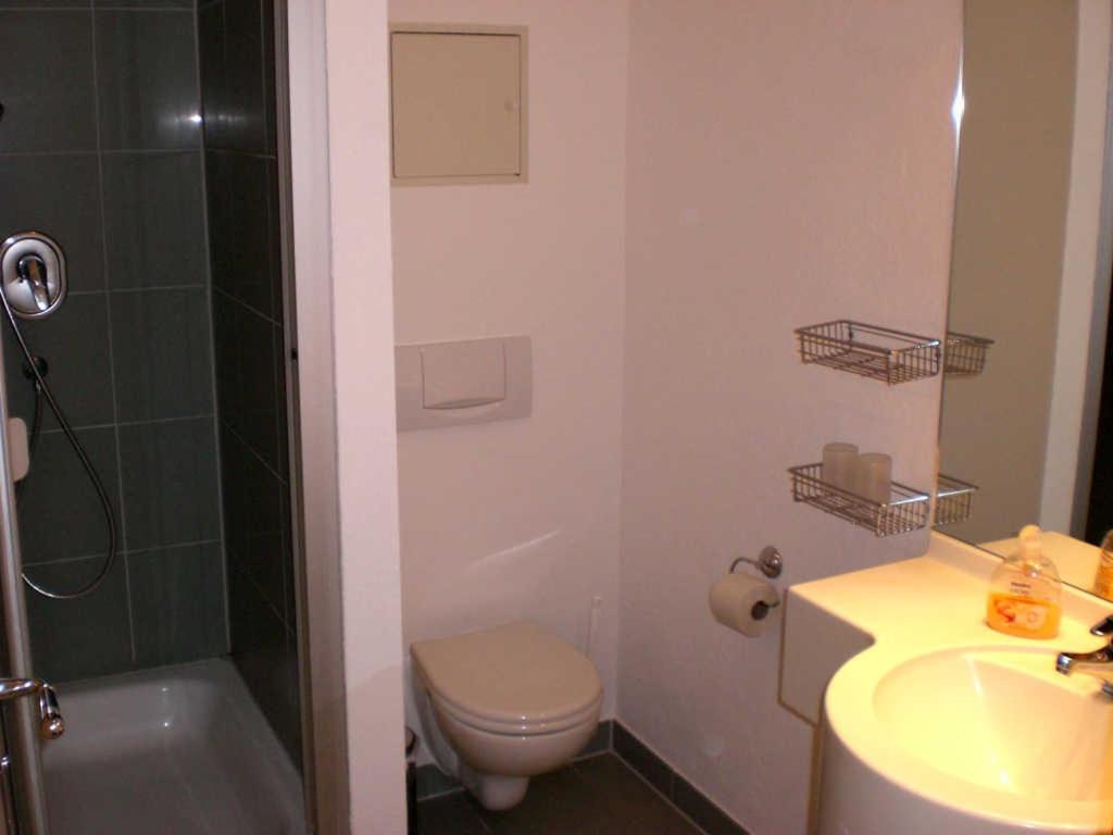 uma casa de banho com um WC, um lavatório e um chuveiro em Strandstraße 32 - 04-21 em Kühlungsborn