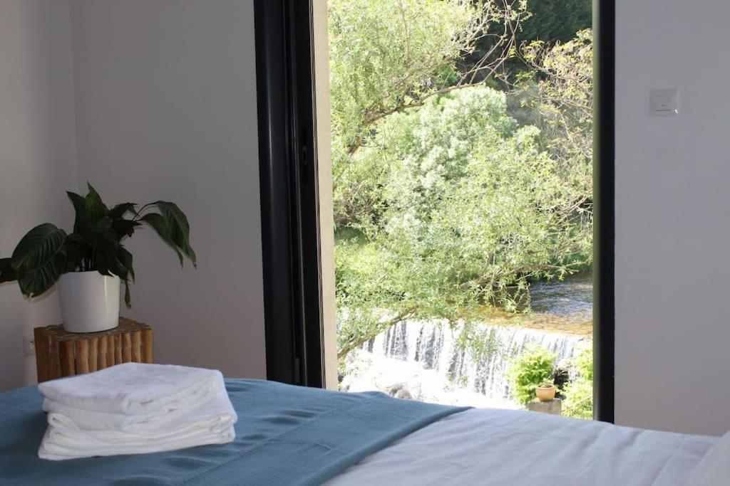 - une chambre avec une fenêtre donnant sur une cascade dans l'établissement Le Moulin du plô du Roy, à Villeneuve-Minervois