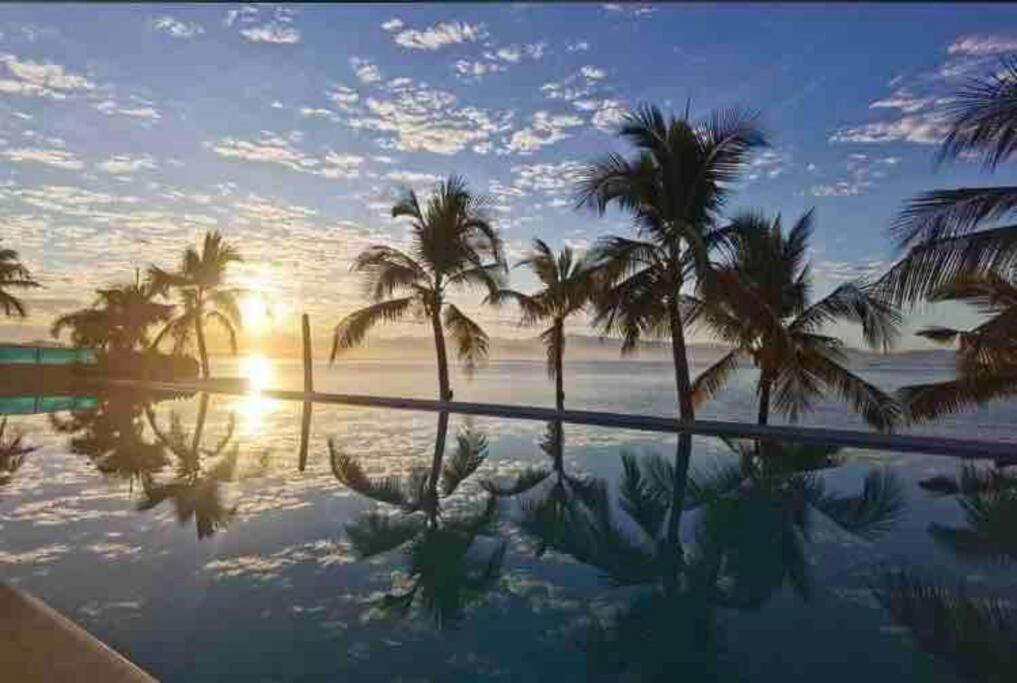 een zwembad met palmbomen en de oceaan bij zonsondergang bij Increible vista en Bucerias en Narval Norte!!! in Bucerías