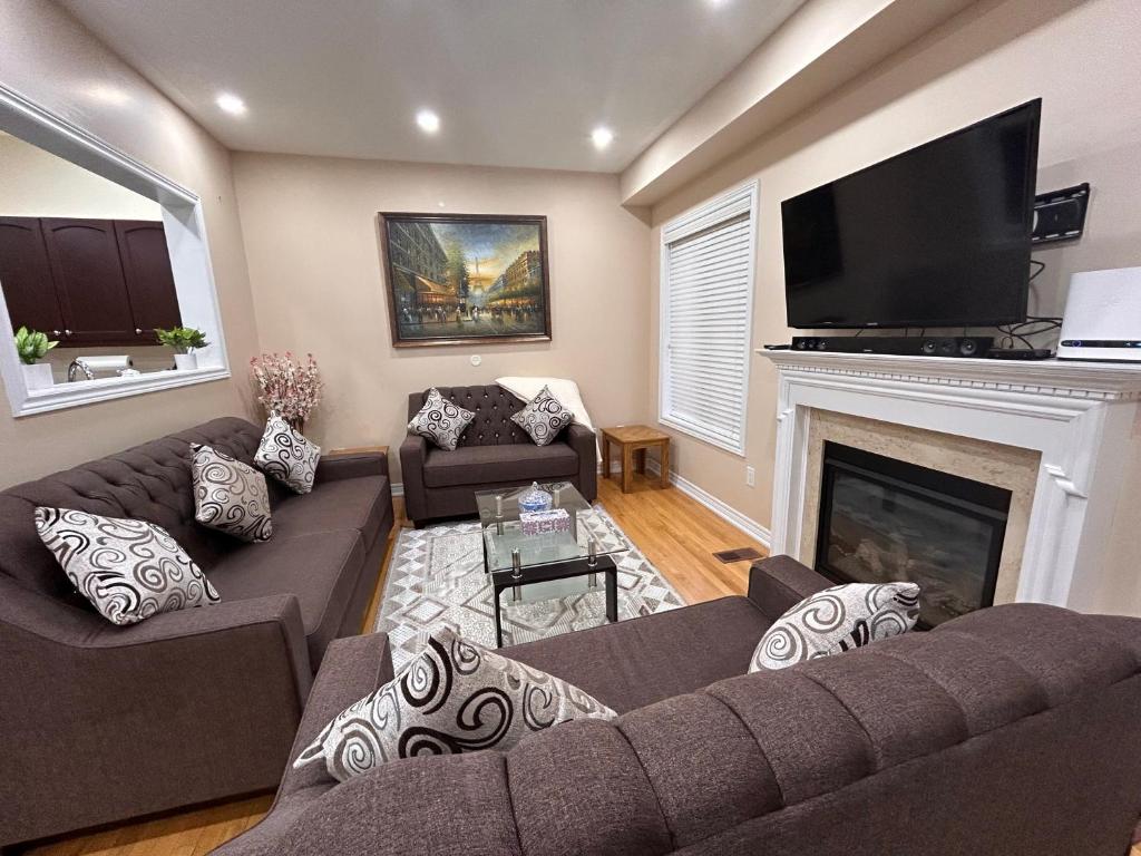 a living room with a couch and a fireplace at Avid vacation palace in Castlemore , Brampton in Brampton